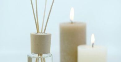 3 white pillar candles on glass bottles