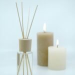 3 white pillar candles on glass bottles