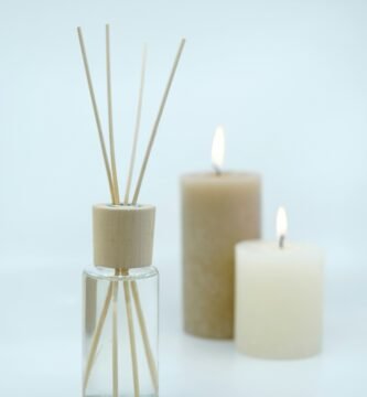 3 white pillar candles on glass bottles